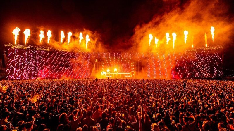 Pyrotechnics firing across the Creamfields main stage above a full festival crowd.